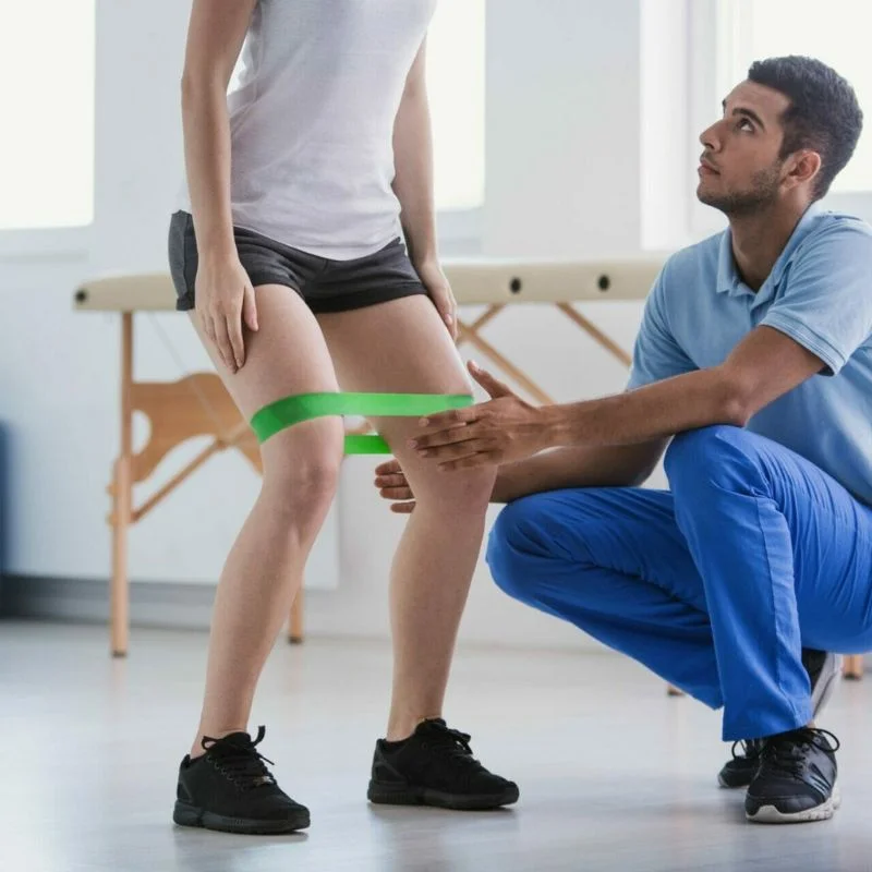 physiotherapist supervising patient resistance band exercise for knee rehabilitation in Whitby