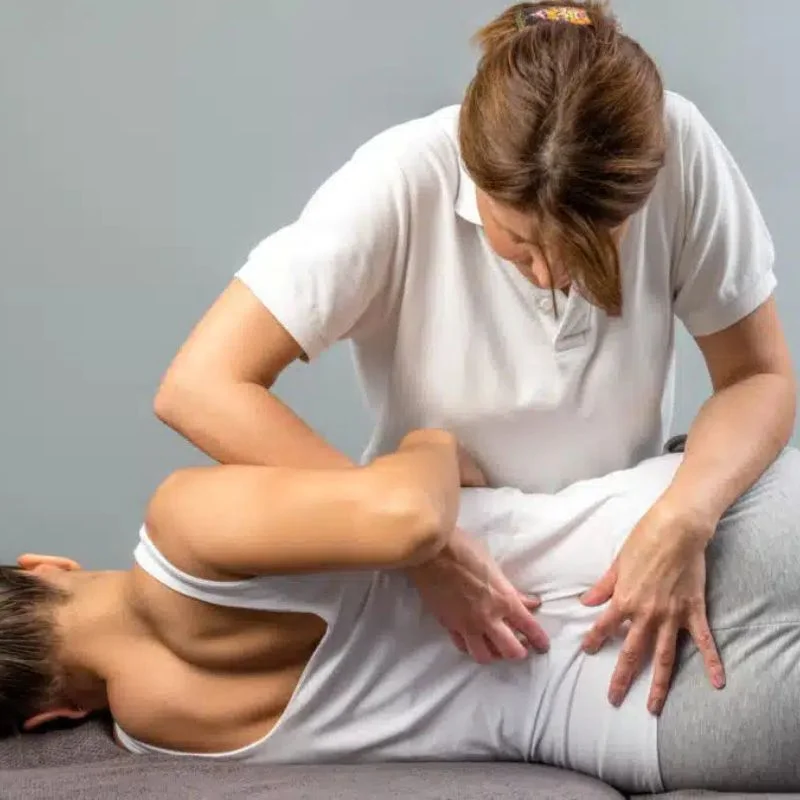 chiropractor treating patient lower back pain in Whitby clinic