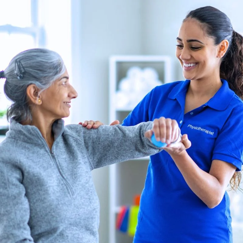physiotherapist assisting senior patient with arm rehabilitation exercise in Whitby