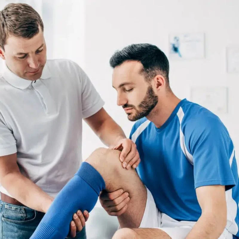 chiropractor examining athlete knee injury for sports rehabilitation in Whitby
